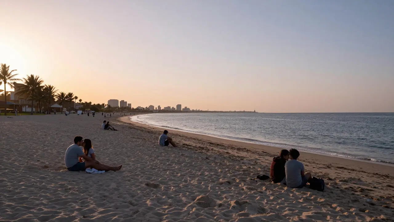 An empty beach at JBR during golden hour with people sitting quietly by the shore.